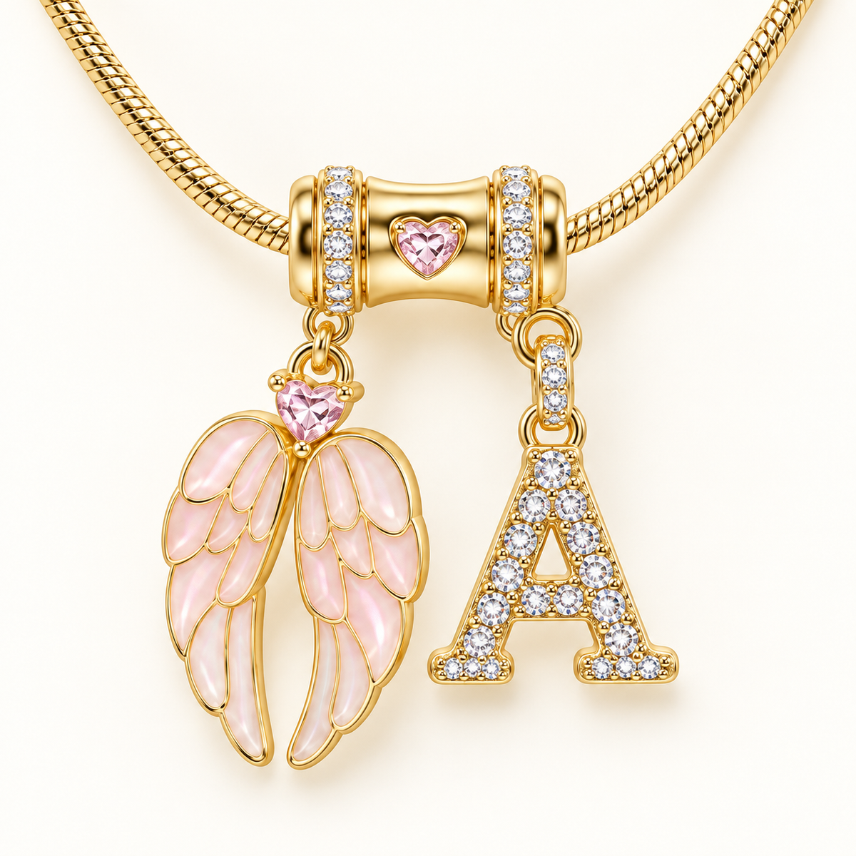 Close-up detail of Personalized Angel Wings Initial Necklace with pink wings, crystal initial charm and gold-tone chain