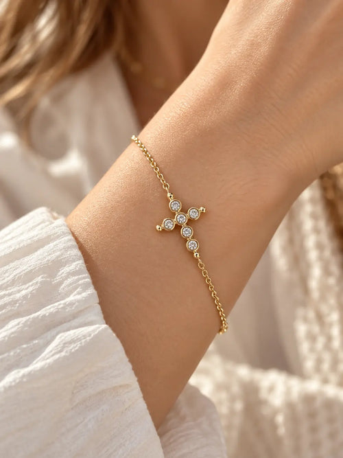 Woman wearing a Bezel Crystal Gold Cross Bracelet with a delicate gold chain and sparkling crystal cross charm, Christian faith bracelet for women.