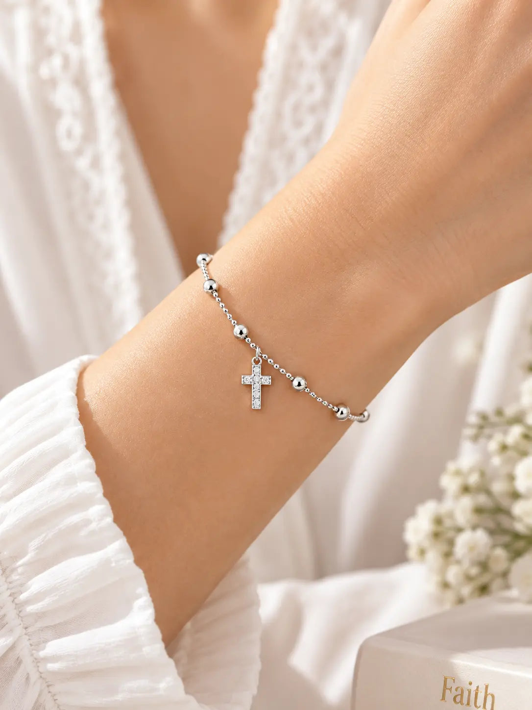 Model wearing the Classic Silver Bead Cross Bracelet, a delicate Christian faith bracelet with polished silver beads and a sparkling cross charm.