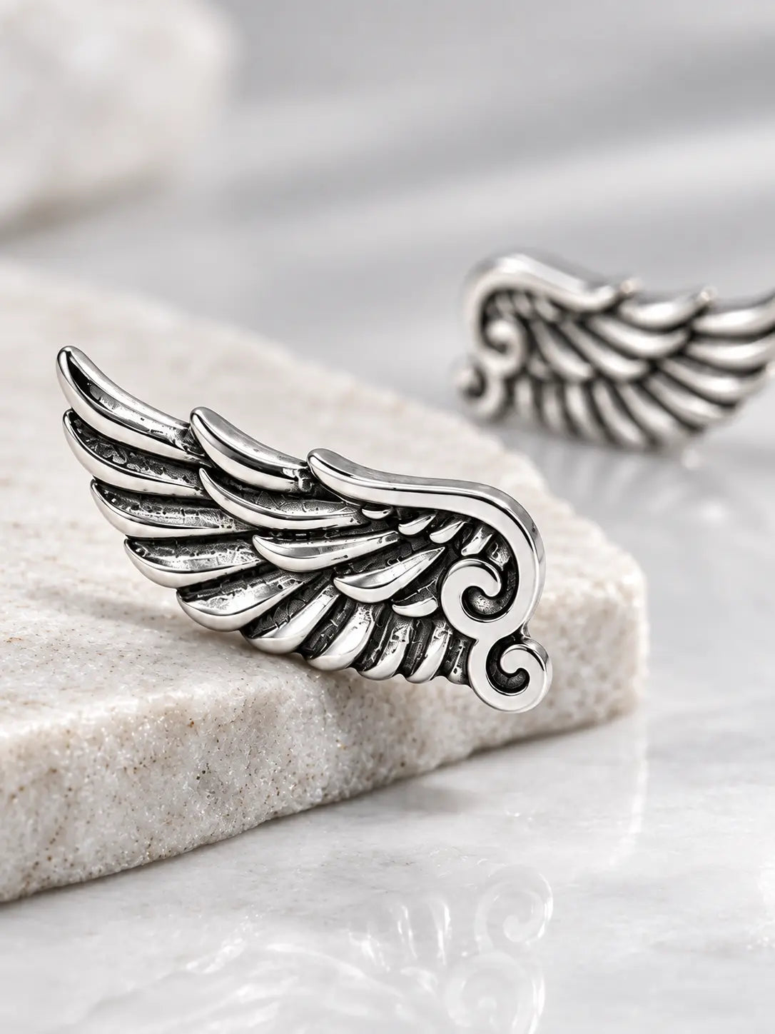 Close-up of S925 sterling silver angel wing climber earrings showing detailed feathers and vintage oxidized finish.