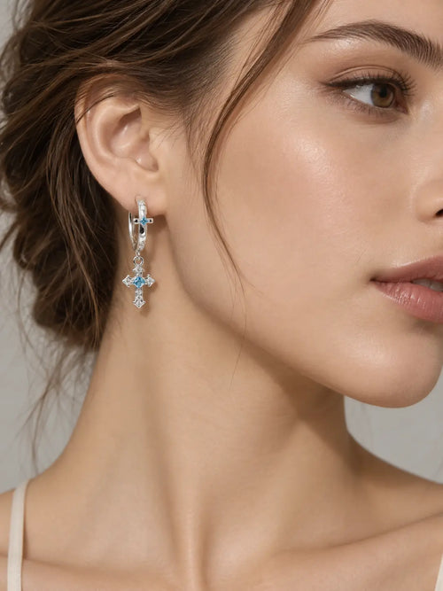YENEAST blue gemstone cross earrings worn as elegant Christian faith jewelry with sparkling silver hoop details.