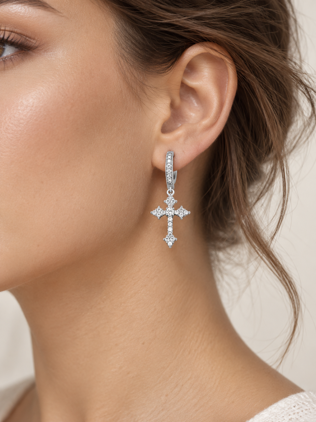 Model wearing a YENEAST silver crystal cross dangle hoop earring as elegant Christian faith jewelry.