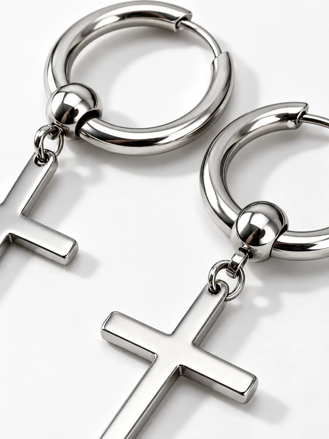 Close-up detail of YENEAST silver cross hoop earrings showing polished metal finish, hoop design, connector bead and cross pendant craftsmanship.
