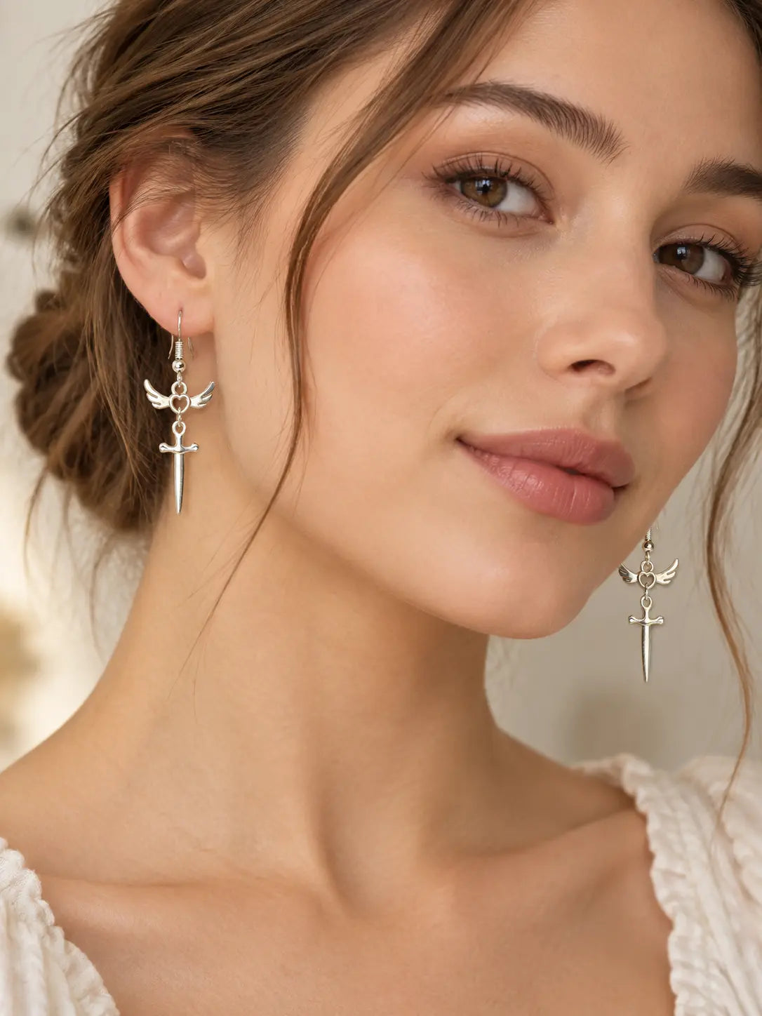YENEAST silver winged heart sword earrings worn as unique faith inspired jewelry with a delicate long dangle style.